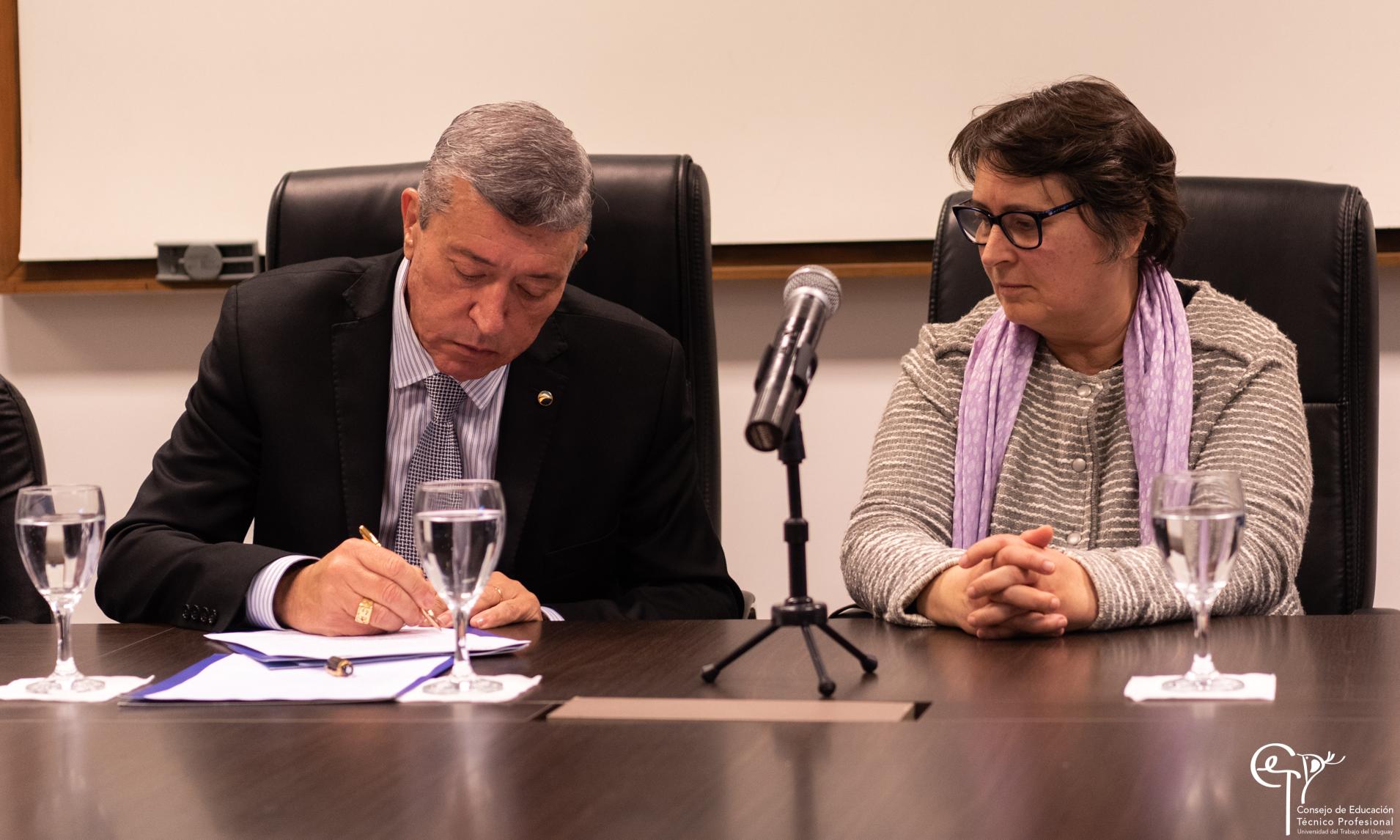 Presidente de CUTCSA firmando convenio junto a Directora General CETP-UTU