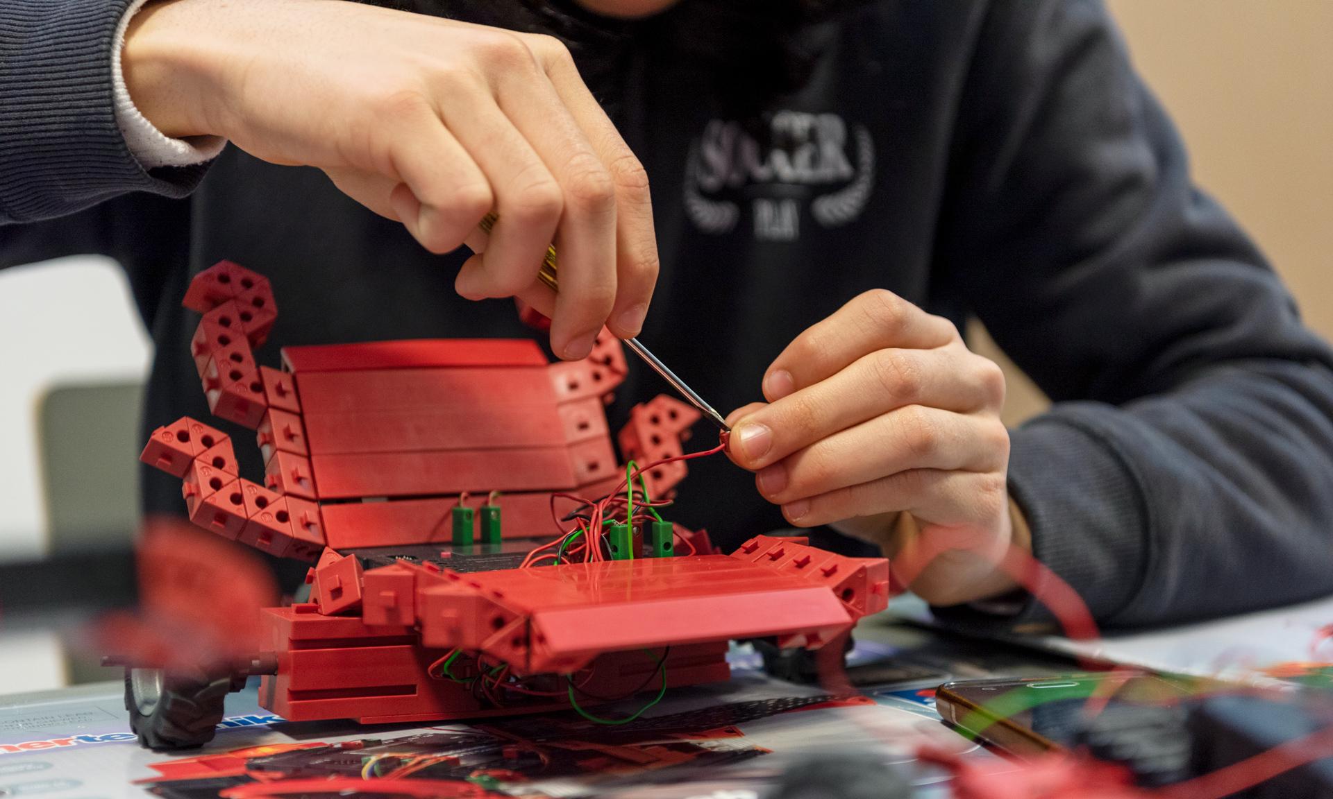 Estudiante trabajando en un proyecto de robótica. 