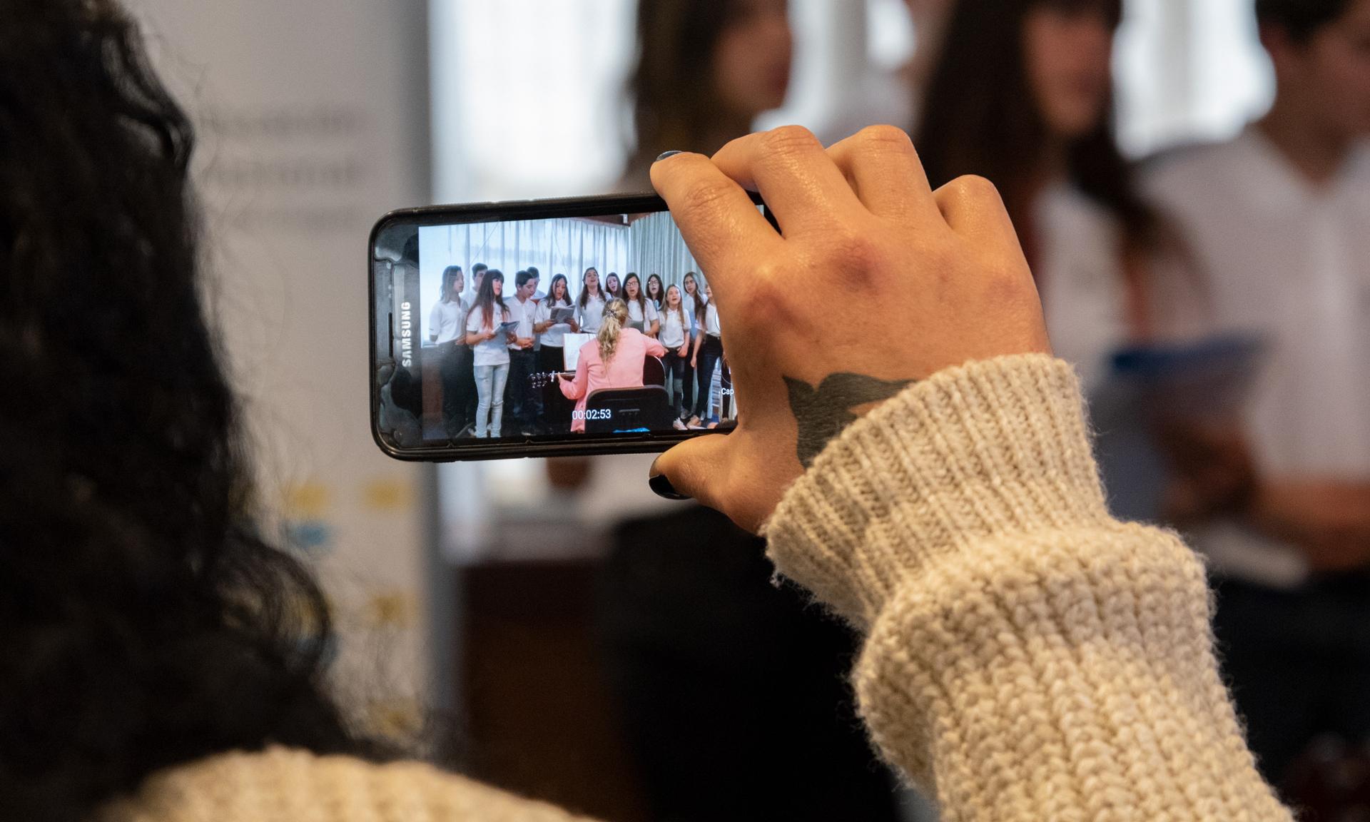 Grabación con un teléfono celular de un coro de estudiantes.
