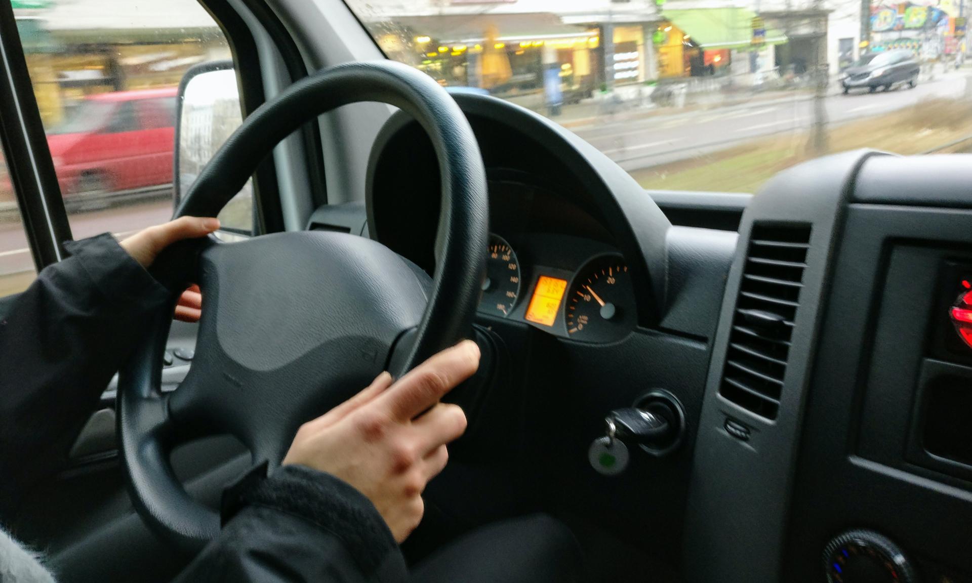 Manos de una persona en el volante de un automóvil en marcha.