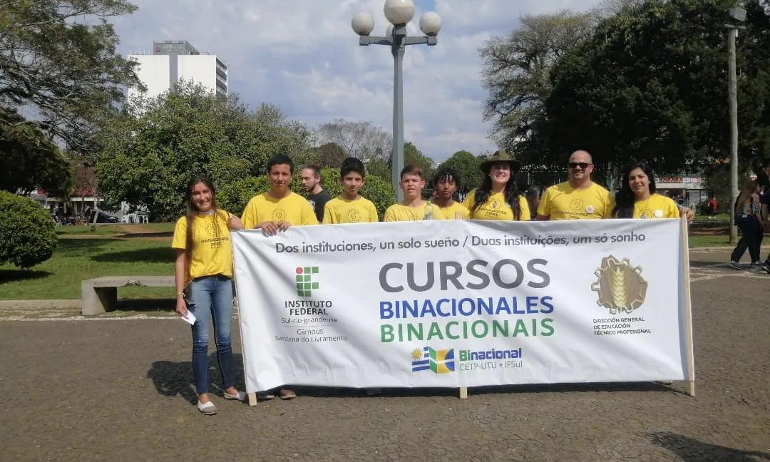 estudiantes con la bandera de cursos binacionales