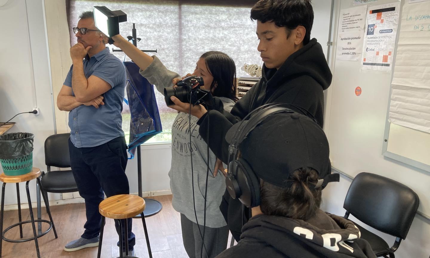 estudiantes arreglan y graban a la par de un adulto
